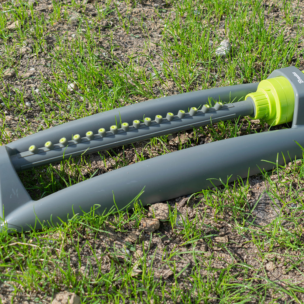 Oscillating sprinkler bar with rows of lime nozzles on grey arm