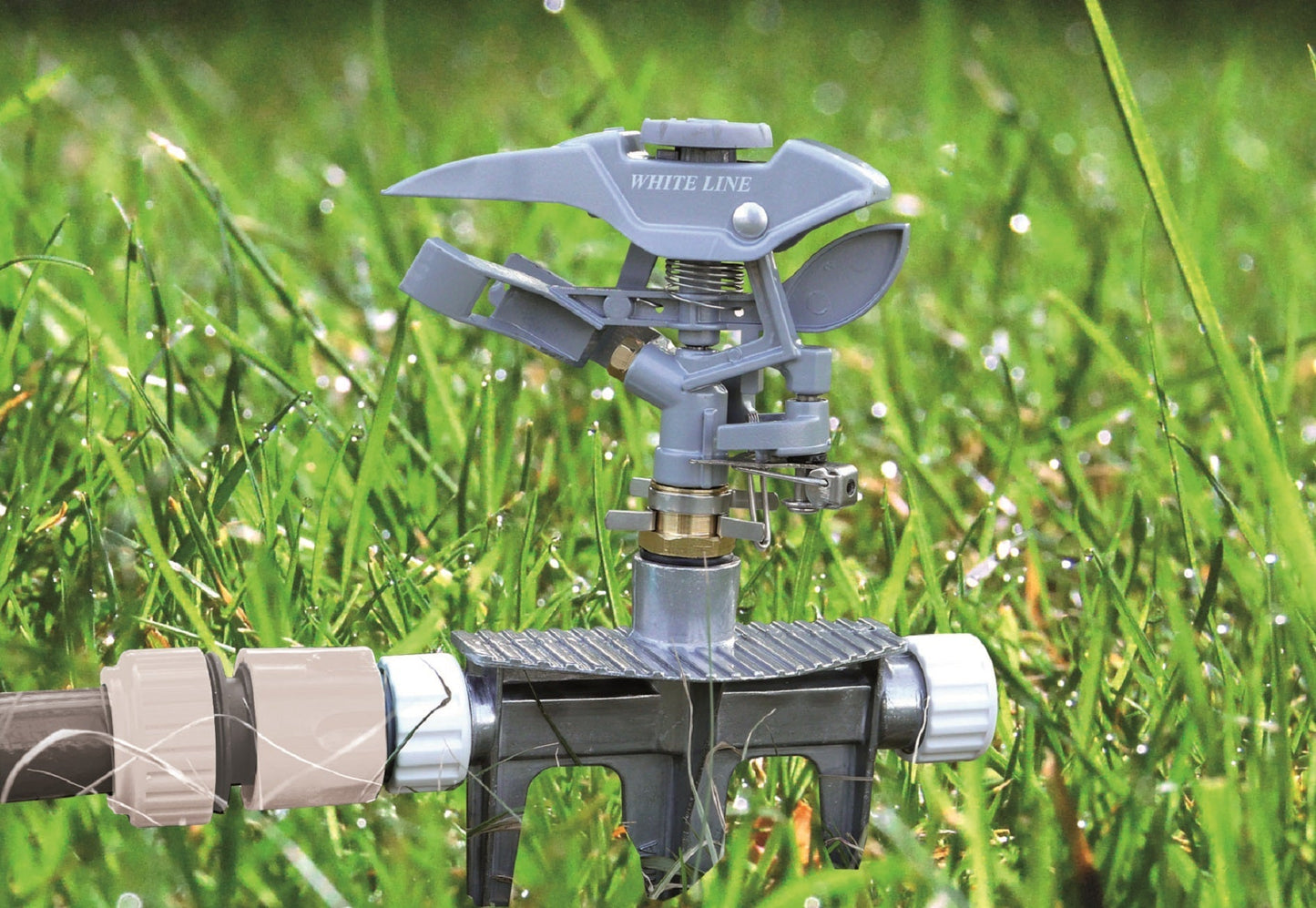Pulsating lawn sprinkler with White Line cover and metal fittings, on grass