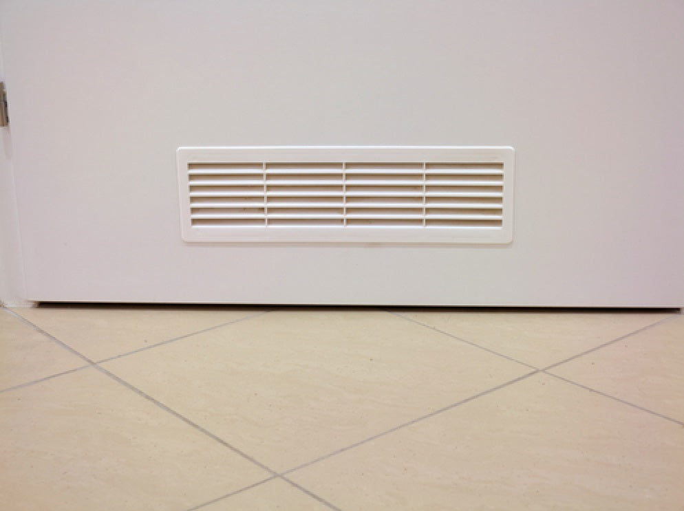Door louvre vent grille in a rectangular recess, white horizontal slats