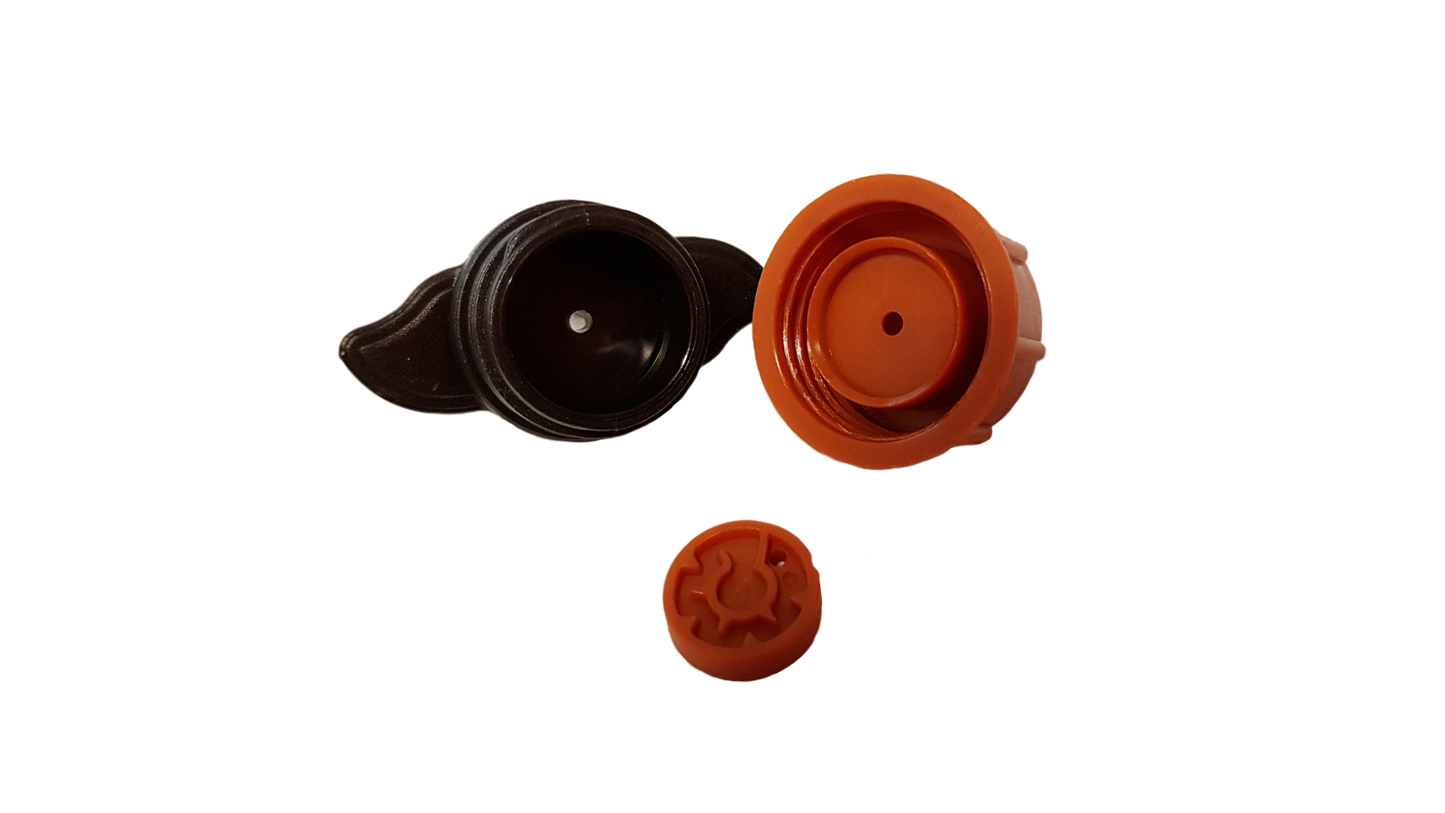 Orange and black dripper components: cap, valve insert, and outlet disc