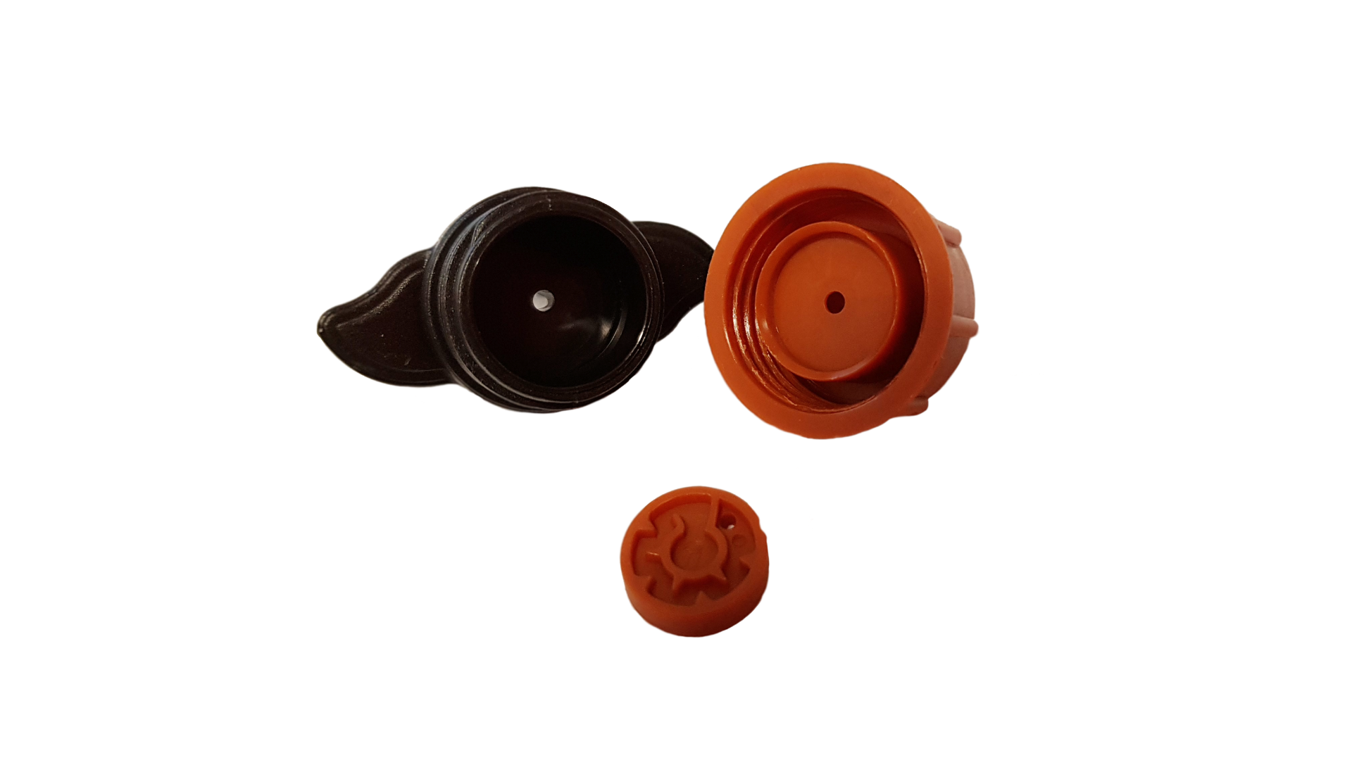 Orange and black dripper components: cap, valve insert, and outlet disc