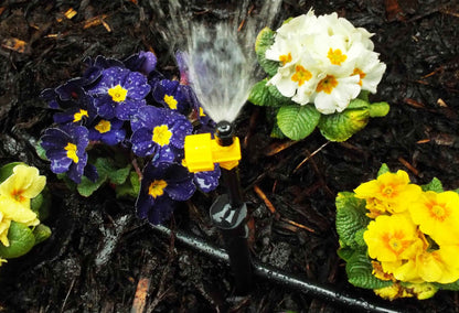 90° sprinkler nozzle with yellow base and black cap, water spray visible