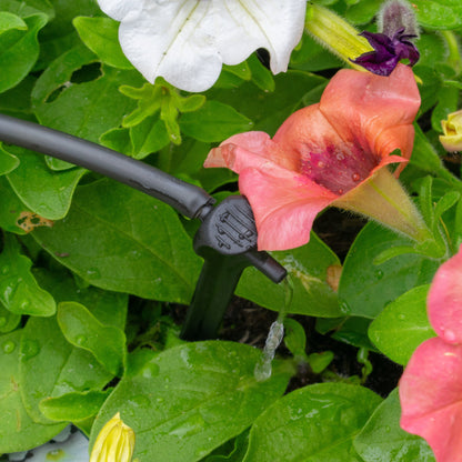 Pressure-compensating spike dripper with visible water stream from emitter