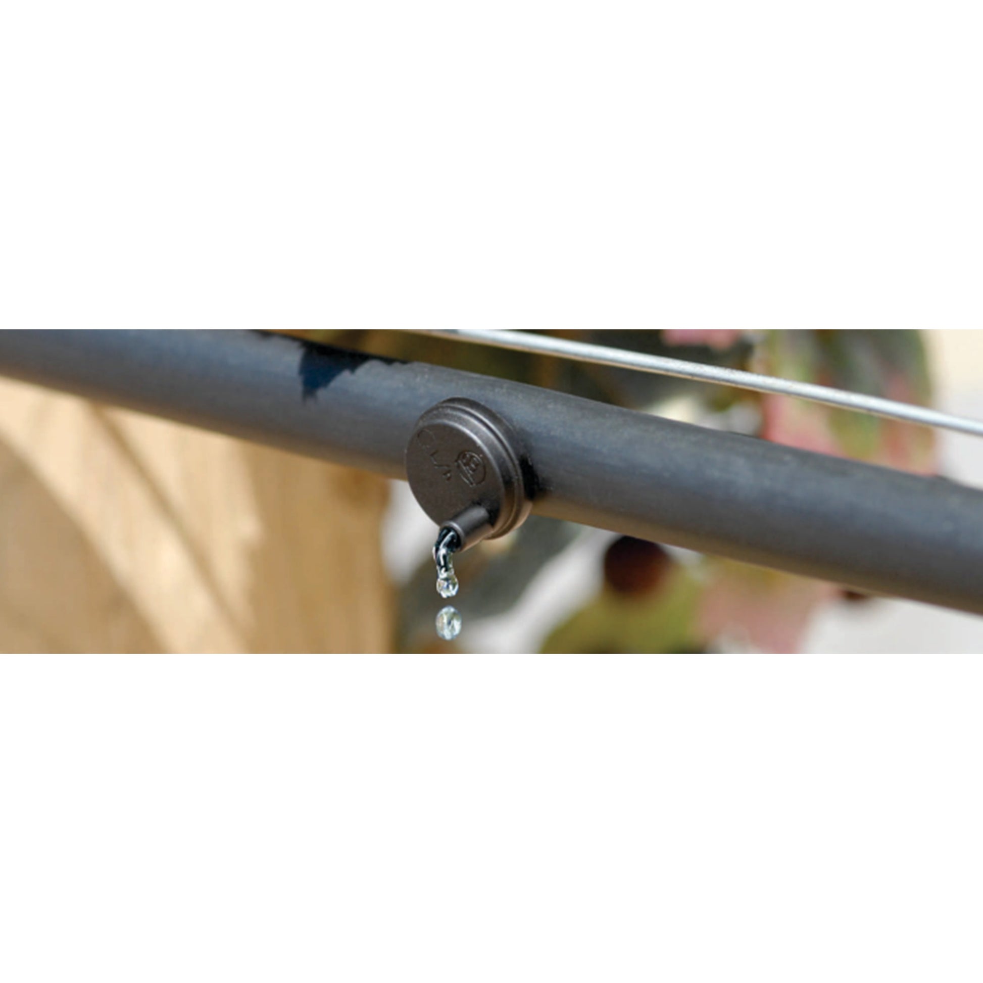 Turbulent flow dripper fitted to irrigation tubing with water flowing from nozzle