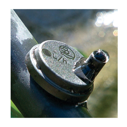 Black dripper cap close-up with inlet outlet spout, turbulent flow emitter