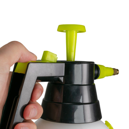 Hand holding the black pump handle of the lime-green nozzle sprayer