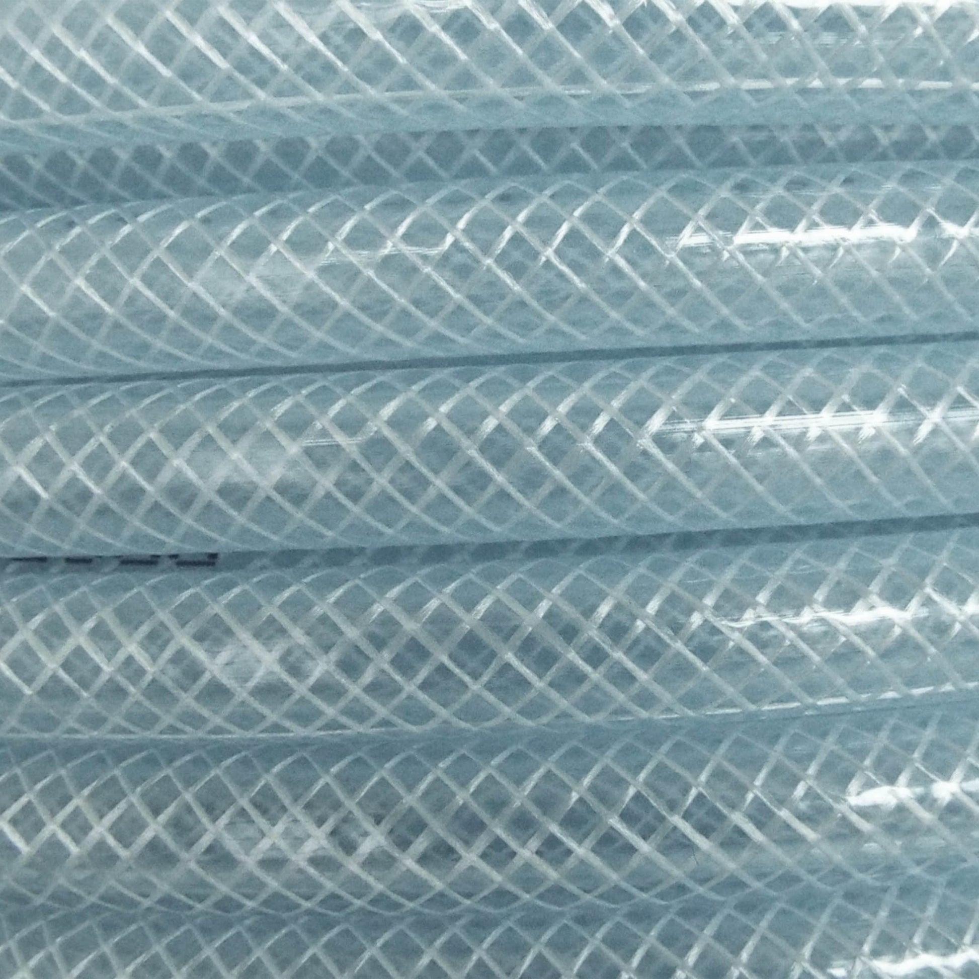 Clear braided PVC pipe close-up, crosshatch mesh pattern on the tubing