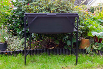 Dog bath with tap stand, black basin on raised metal frame in garden