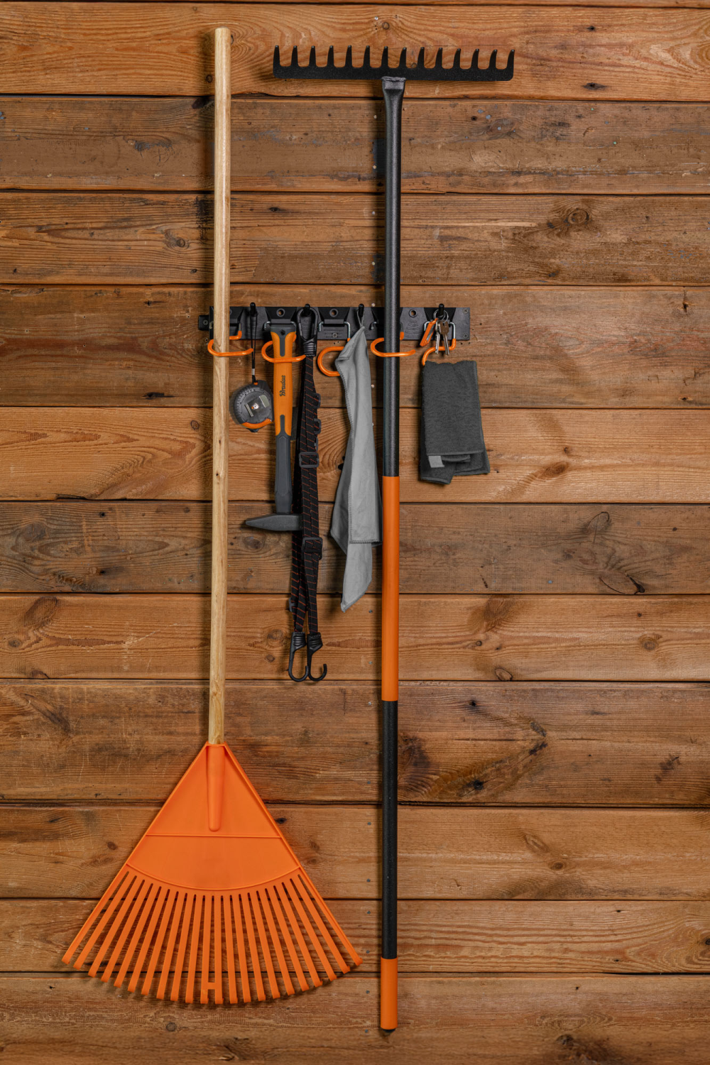 Werkzeugschiene an Holzwand mit orange S-Haken und Werkzeugen