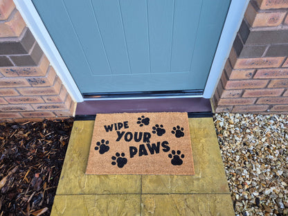 Coir doormat “WIPE YOUR PAWS” with paw prints, placed at front door step