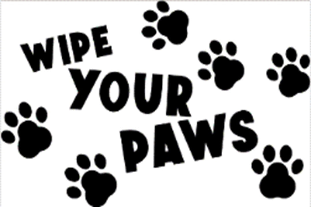 Close-up view of “WIPE YOUR PAWS” doormat with black paw prints