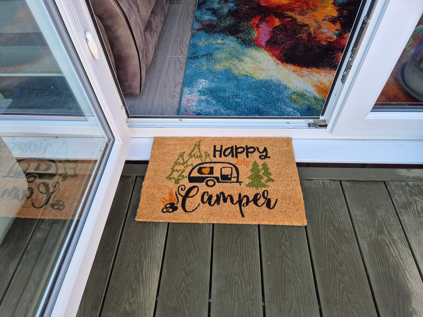 “Happy Camper” doormat 60cm x 40cm at patio door, orange-brown coir