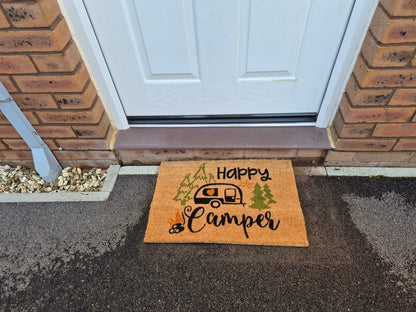 “Happy Camper” front door doormat with caravan icon and green tree details