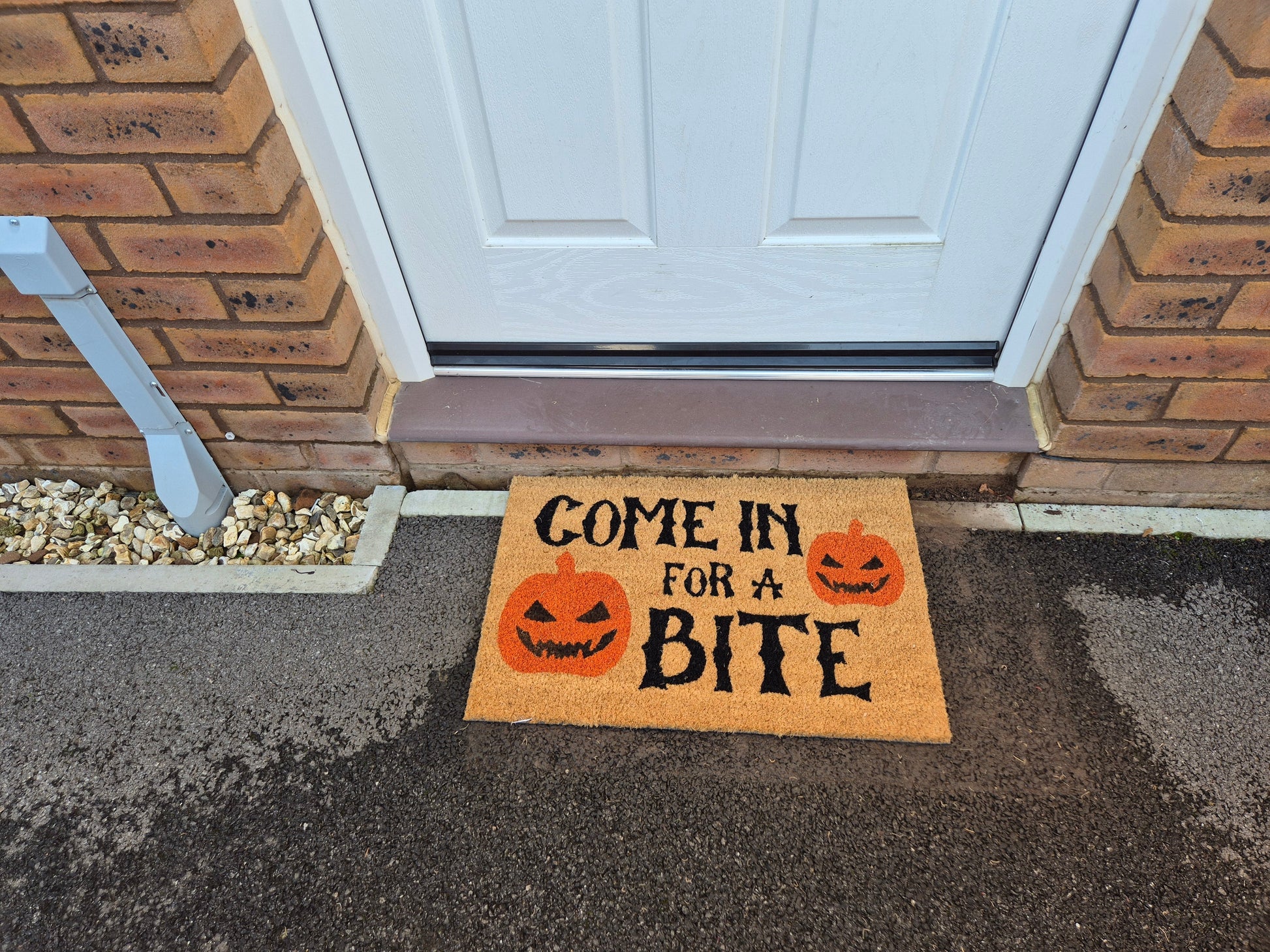 Doormat with 'Come in for a Bite' and three orange jack-o'-lanterns
