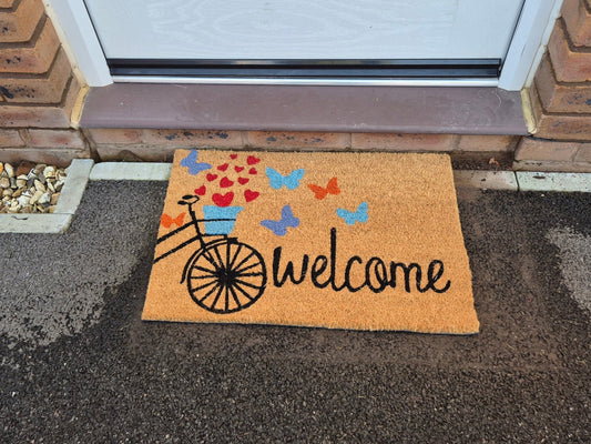 Beige 60x40cm doormat: 'welcome' with bicycle, hearts and blue butterflies