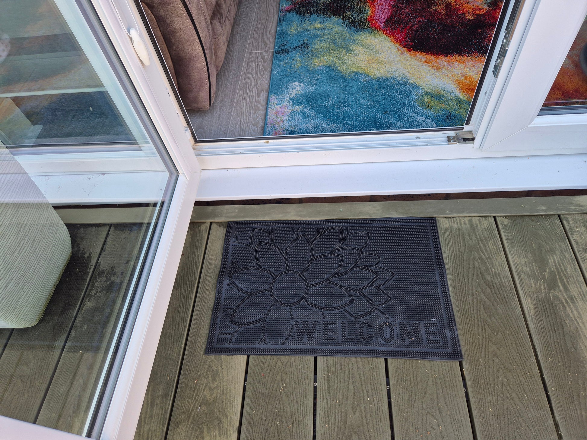 Black rubber entry mat with flower embossing and 'WELCOME' lettering