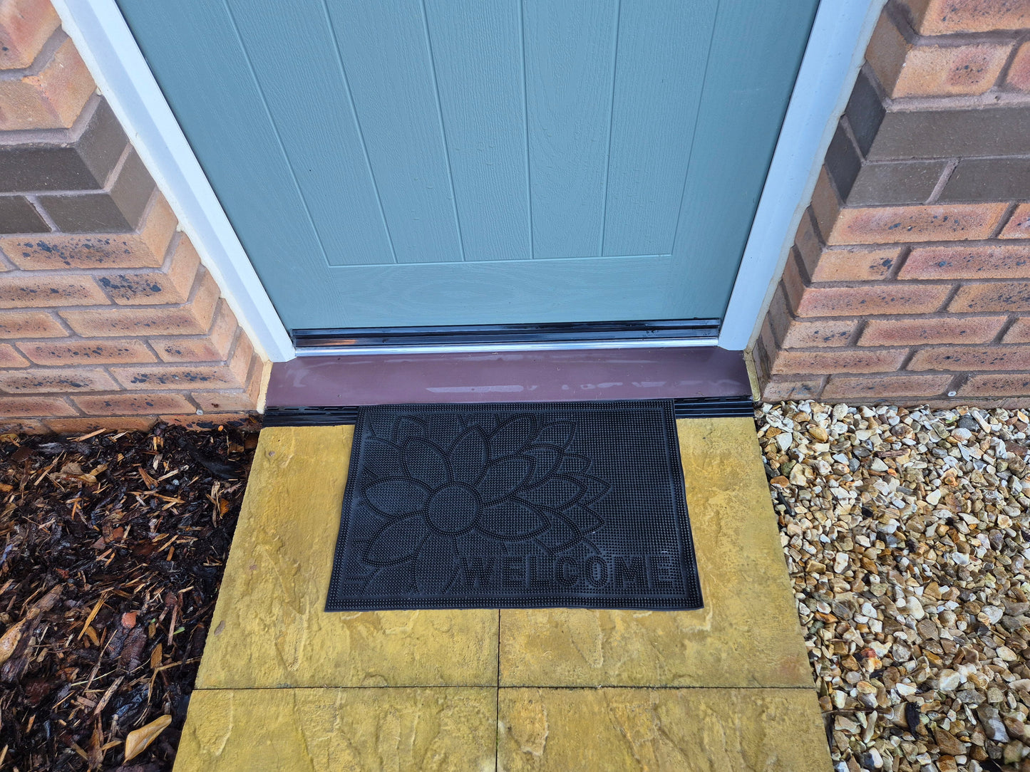 Black rubber doormat 60x40cm with flower and 'WELCOME' on entryway