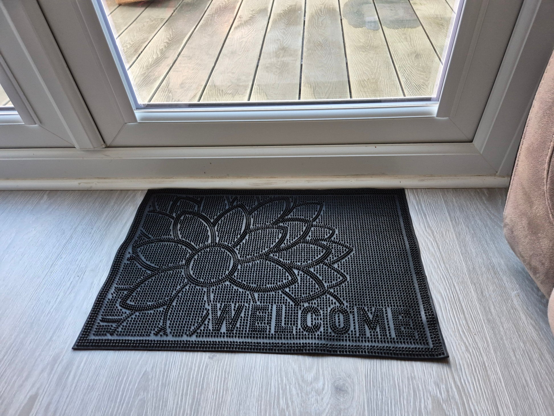 Black rubber doormat 60x40cm with embossed flower and 'WELCOME' text