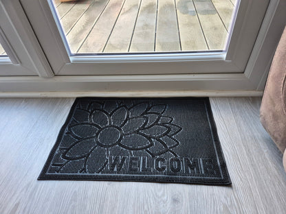 Black rubber doormat 60x40cm with embossed flower and 'WELCOME' text