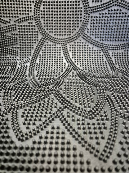Close-up of black rubber doormat dots with embossed flower and 'WELCOME'