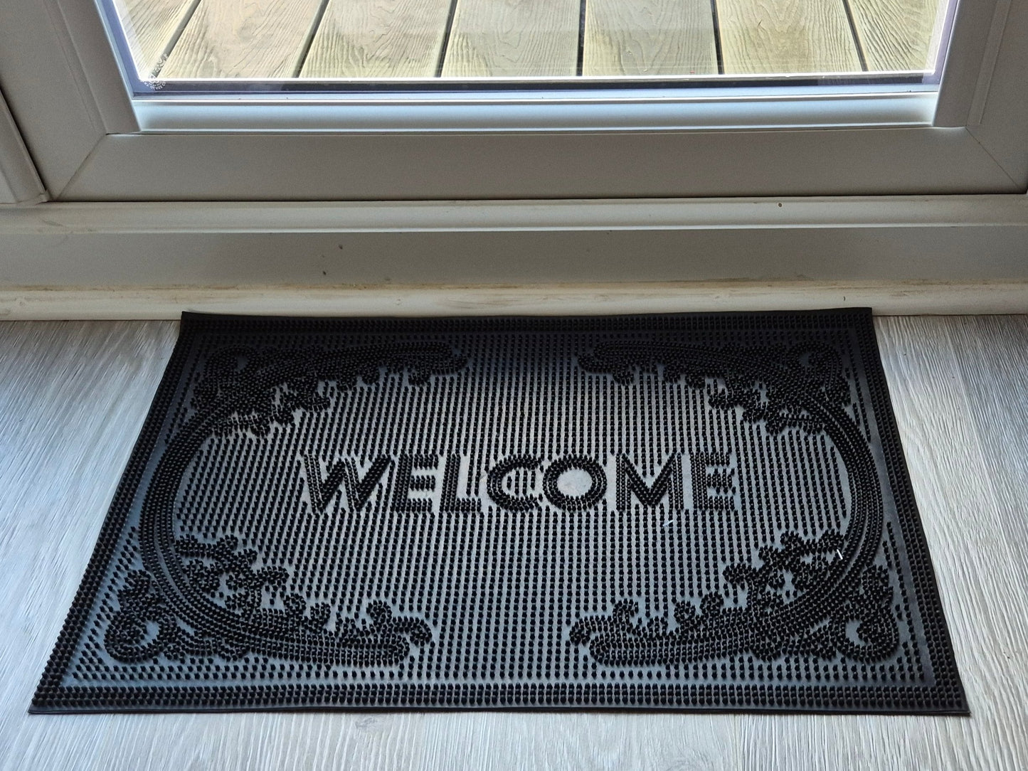 Black rubber welcome doormat, 60 x 40 cm, raised “WELCOME” lettering