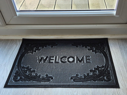 Black rubber welcome doormat, 60 x 40 cm, raised “WELCOME” lettering