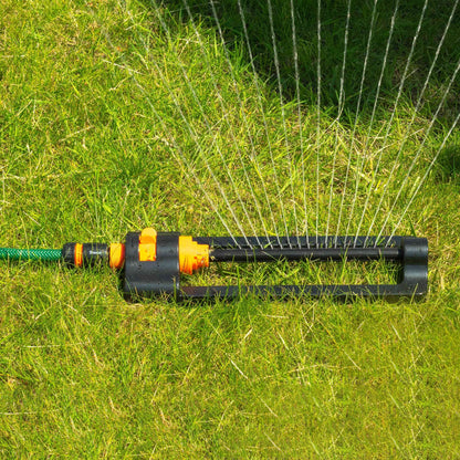 Oscillating sprinkler on grass with orange outlets and a steady water jet