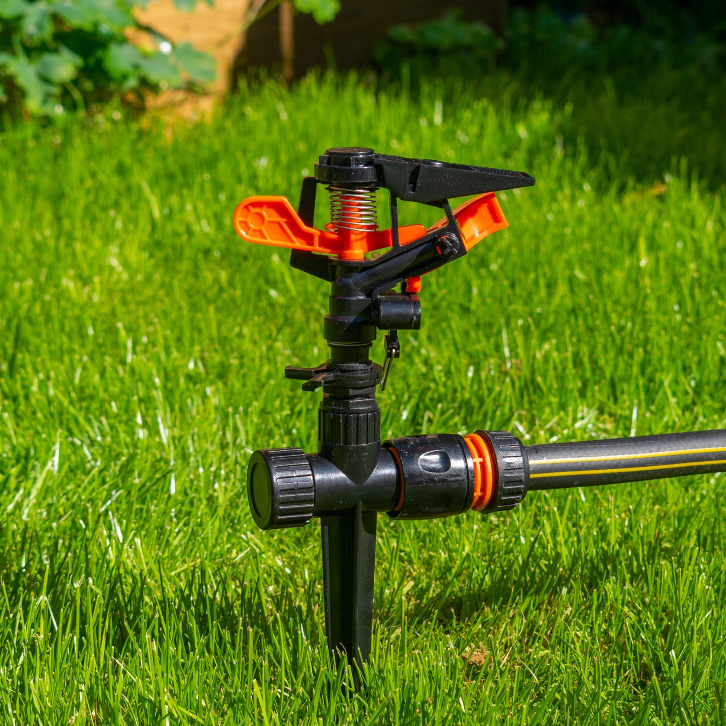 Pulsating sprinkler head on spike, black body with orange adjustment tabs
