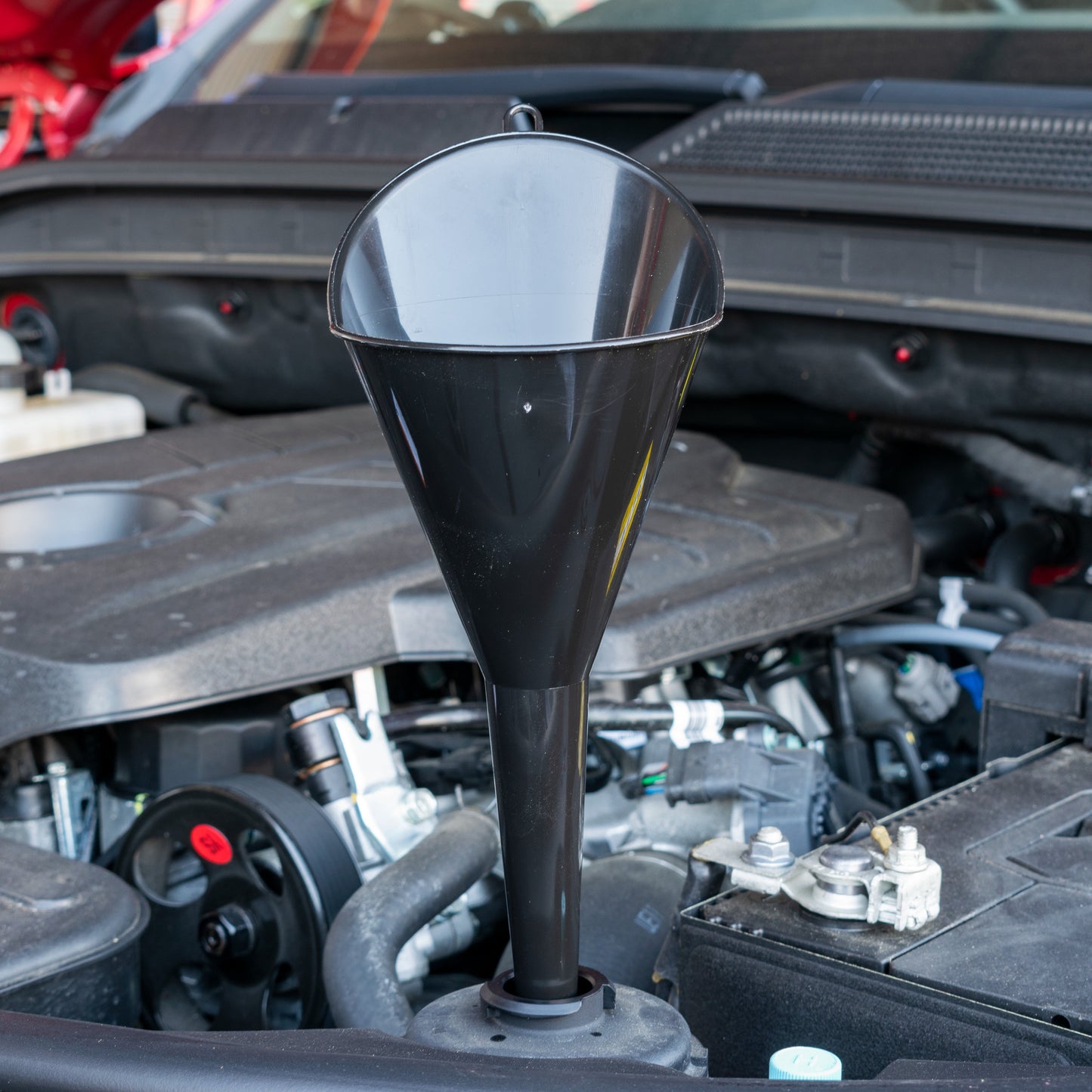 Black angle-top funnel, pointed spout facing up; wide rim at the top