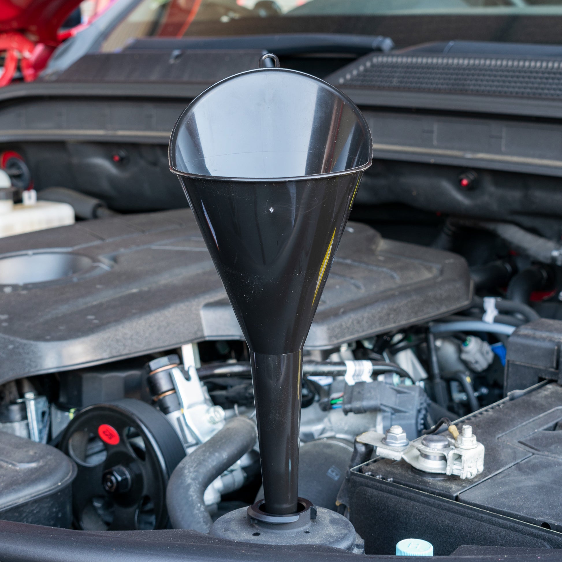 Black angle-top funnel, pointed spout facing up; wide rim at the top