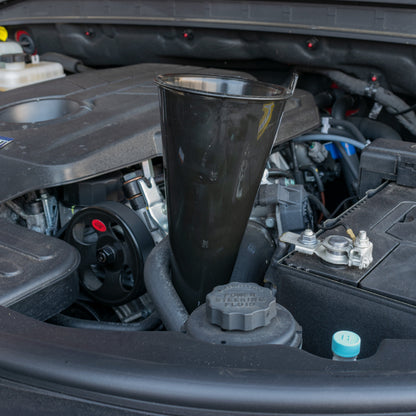 Long black funnel standing upright in car engine compartment