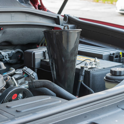 Long black funnel in engine bay above hoses and engine parts