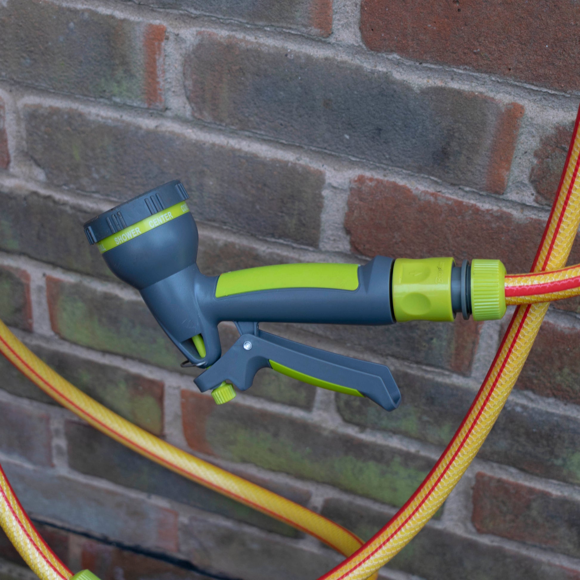 Lime hose water sprayer gun with connected hose end and spray controls