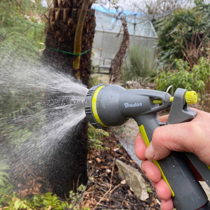 Lime garden hose water sprayer gun shooting a wide misty water spray