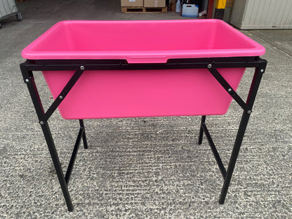 Pink dog bath tub with black stand, front view with legs and support frame