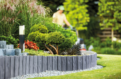 Gray plastic lawn edging border with wood-effect panels and upright stakes