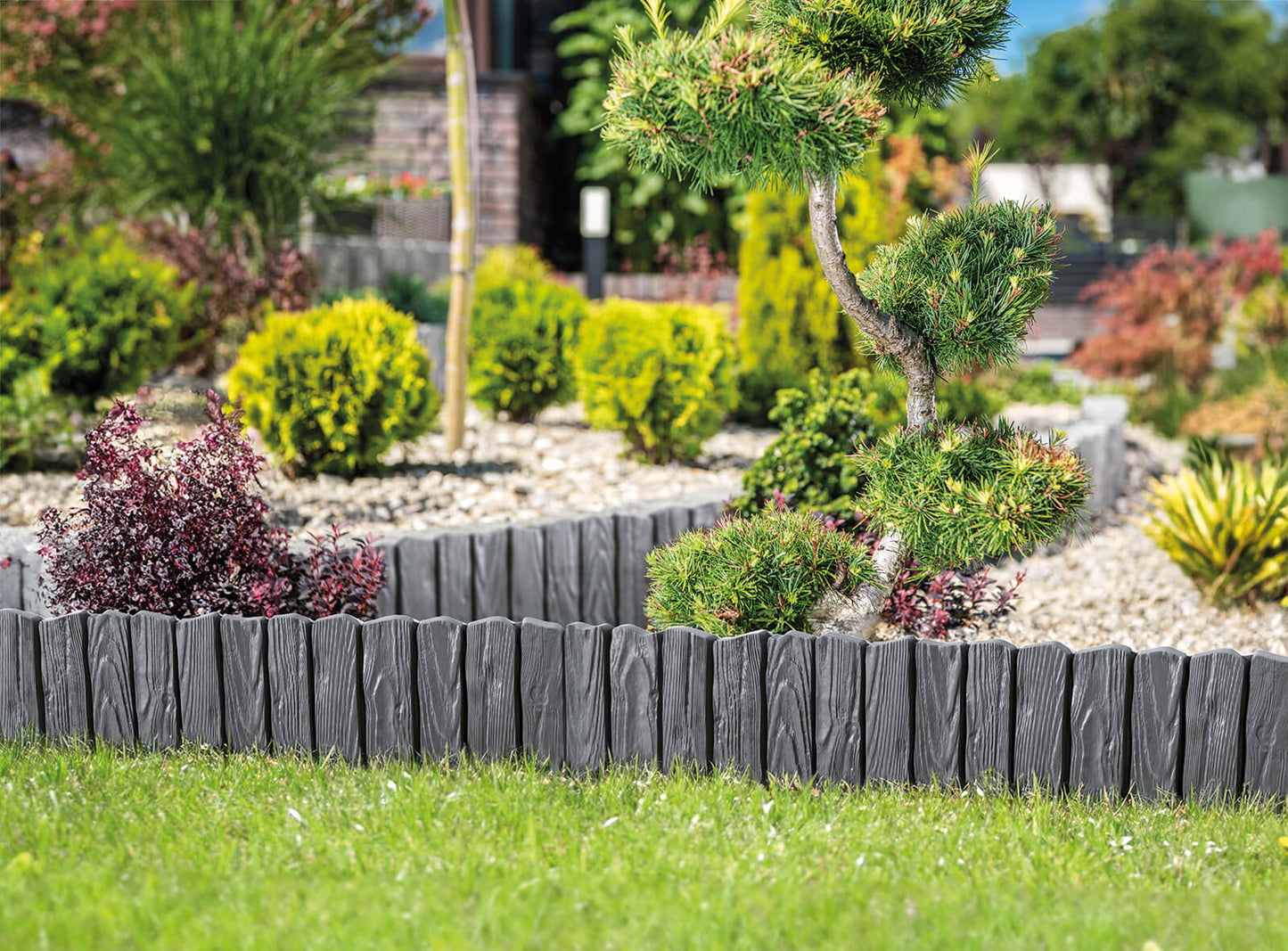 Gray plastic lawn edging border with wood-effect slats and pointed stake ends