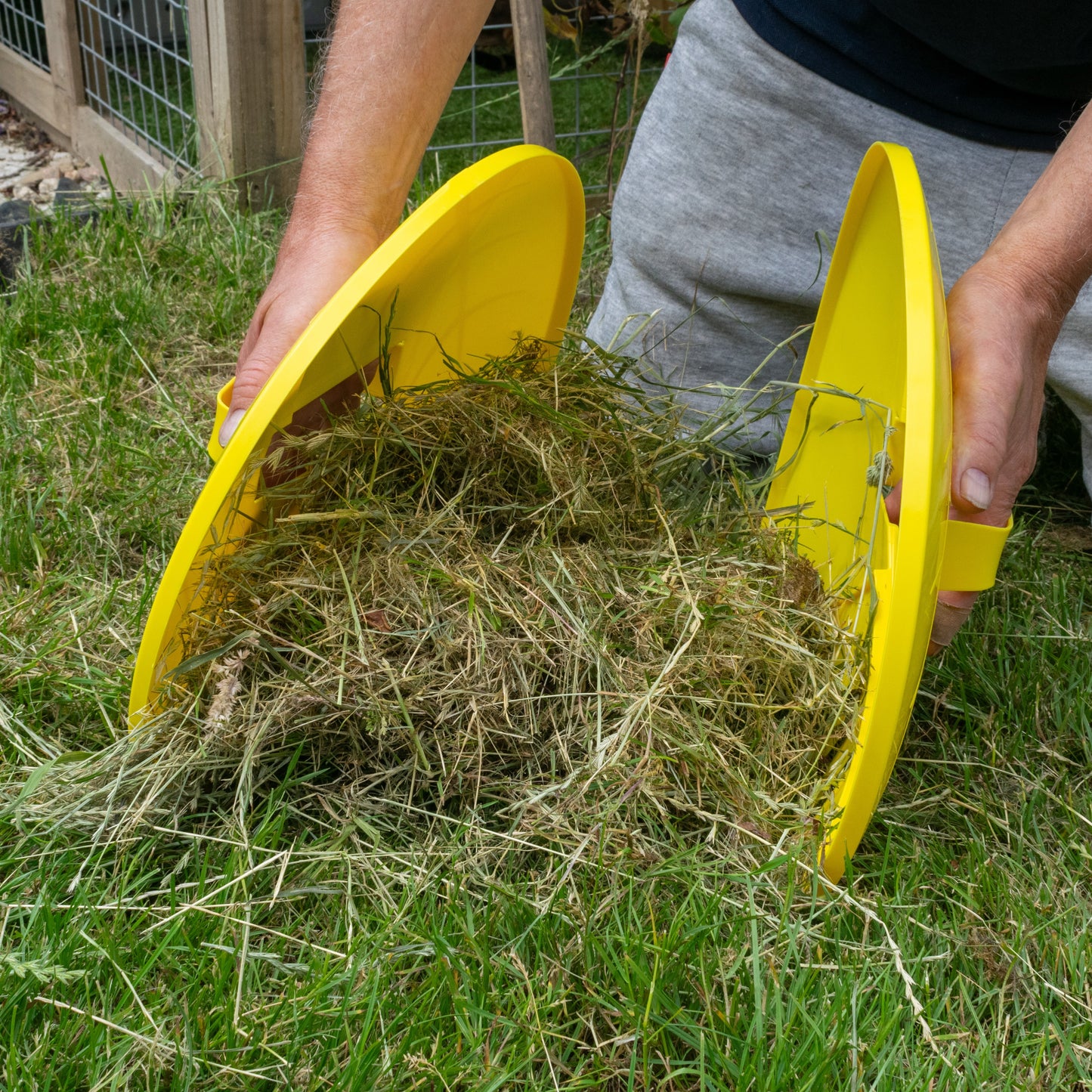 Yellow leaf grabber garden scoop lifting grass and leaves for cleaning