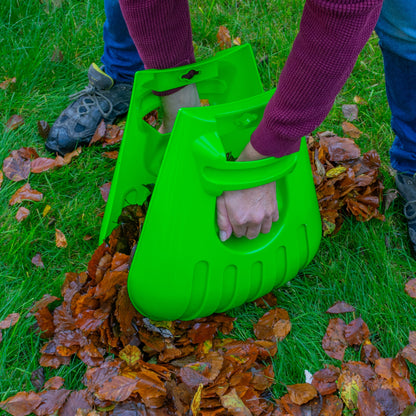 Large green leaf grab scoop in hand, ready to pick up fallen leaves on grass