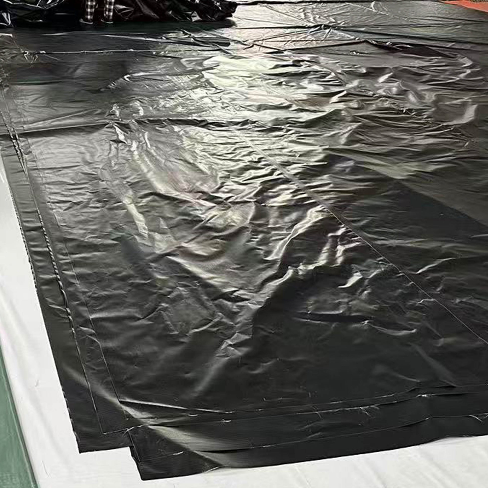 Black PVC pond liner, square sheet with creases and welded seams