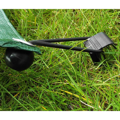 Ground stake securing a black irrigation pipe with an integrated U-shaped clip