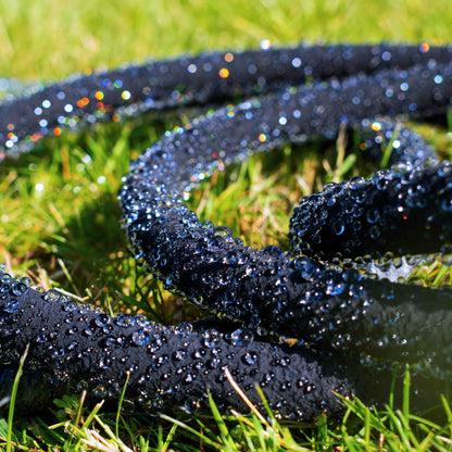 Porous pipe with connector laid in grass, dark perforated tubing with flowing droplets