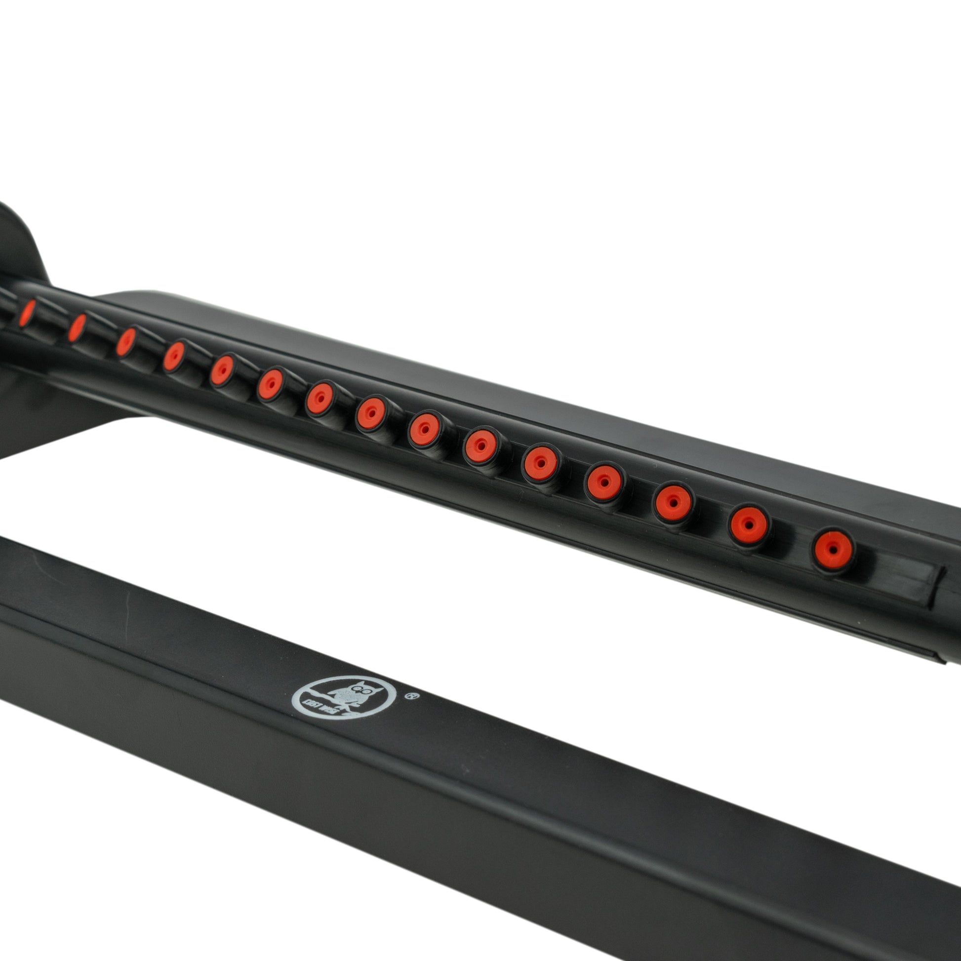 Row of spray holes on black oscillating sprinkler bar with orange nozzle tips
