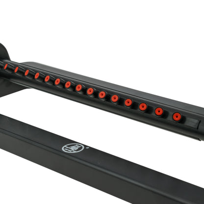 Row of spray holes on black oscillating sprinkler bar with orange nozzle tips