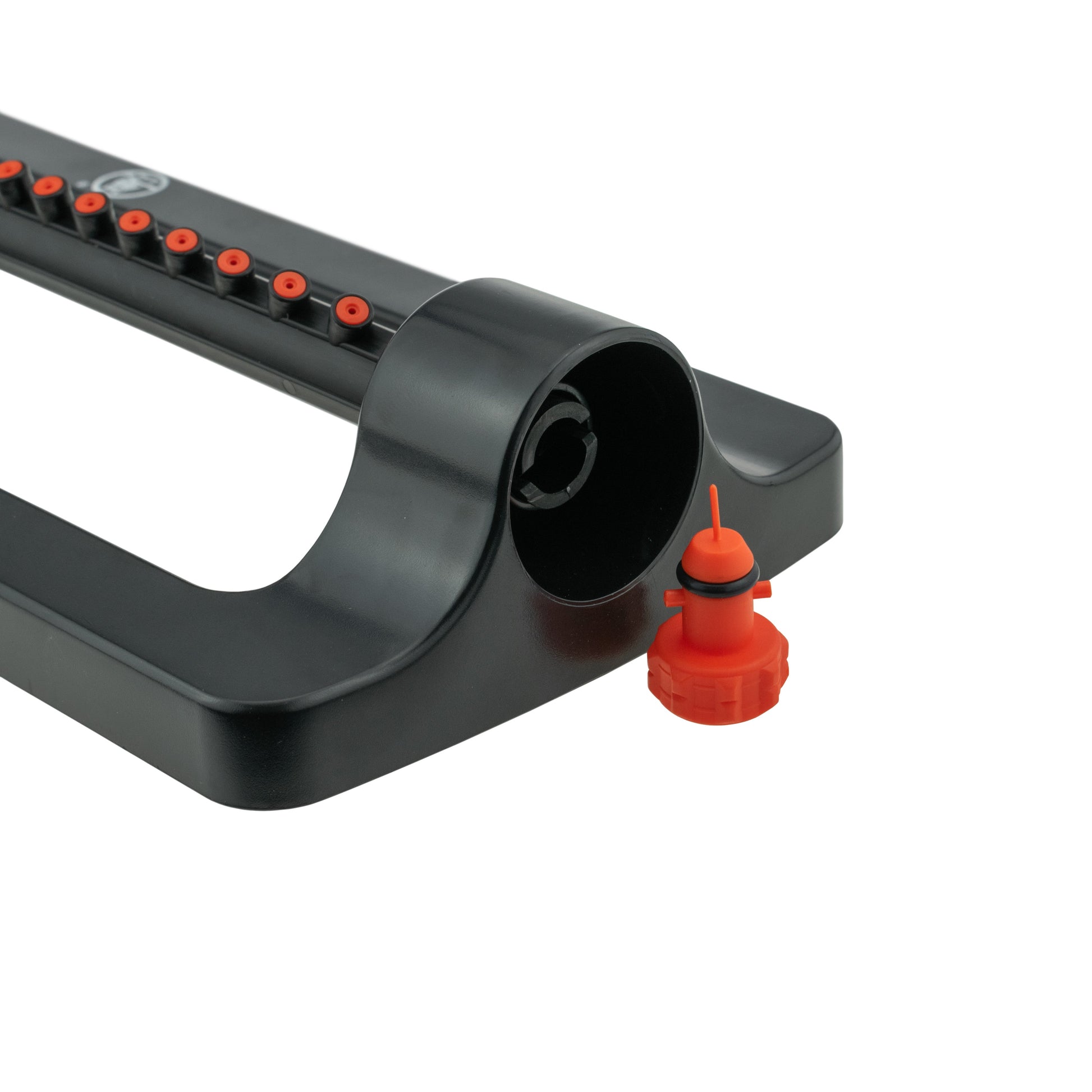 Black sprinkler base end with orange connector cap beside the hose outlet