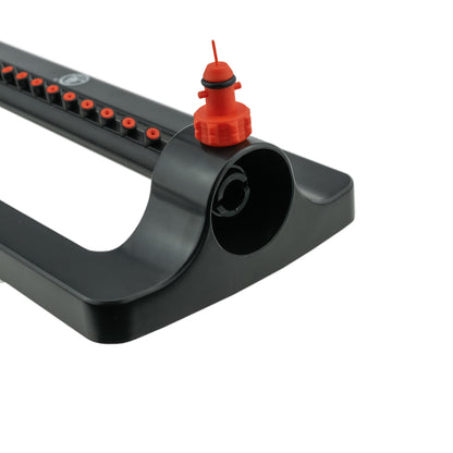 Oscillating sprinkler front with orange inlet cap on black housing