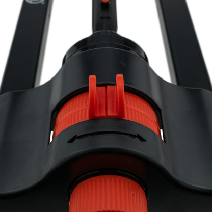 Black sprinkler head with red-orange collar and orange base ring