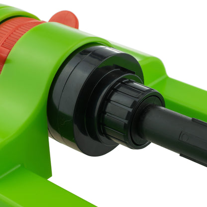 Oscillating sprinkler close-up of black water connector on green housing