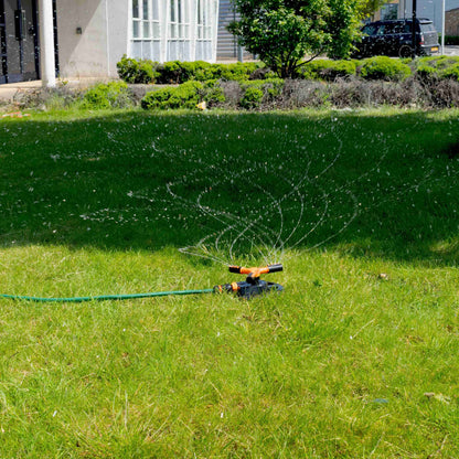 Rotationssprinkler mit 3 Armen im Sprühbetrieb, Wasserstrahlen im Rasenbereich