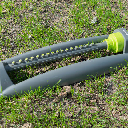 Oscillating sprinkler bar with rows of lime nozzles on grey arm